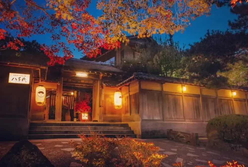 紅葉と行灯に照らされた料亭の入り口