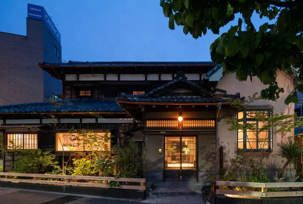 夕暮れに明かりが灯る木造二階建ての料理店